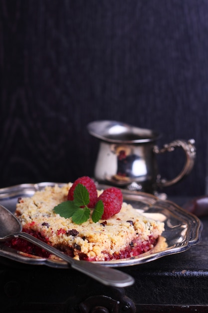 Raspberry crumble in a metal plate with a fork