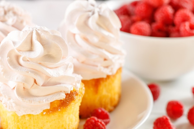 Raspberry cupcakes with berries on a white background