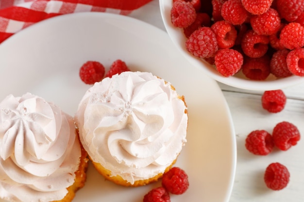 Raspberry cupcakes with berries on a white background