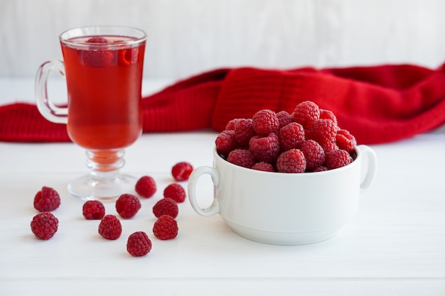 Raspberry drink on white table glass cup with compote fresh raspberries