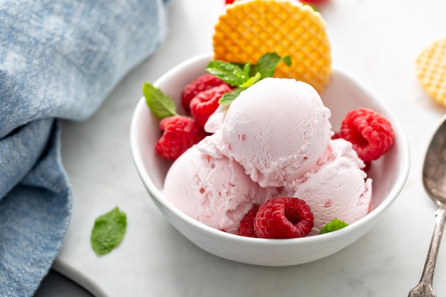 Raspberry ice cream in a bowl with fresh berries