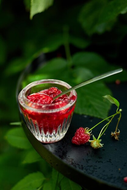 Raspberry jam in glass bowl on a black background