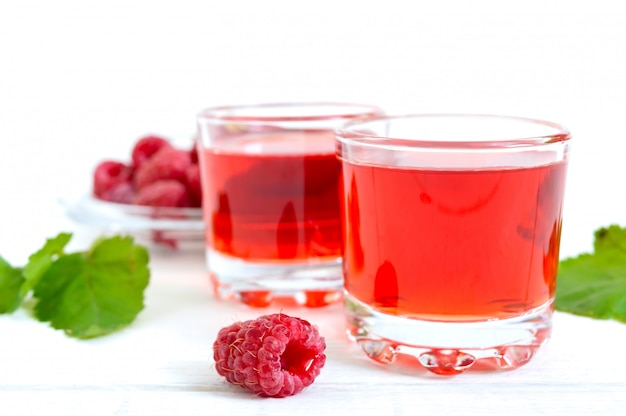 Raspberry juice in glasses and fresh berries