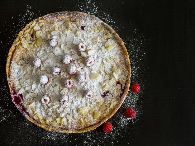 Raspberry and mascarpone pie on a black surface