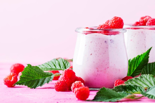 Photo raspberry smoothie with berry and yogurt on pink background selective focus