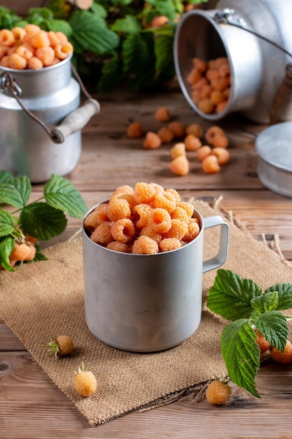 Raspberry yellow Bright sweet summer berries Vegetarian healthy dessert in a mug on wooden table