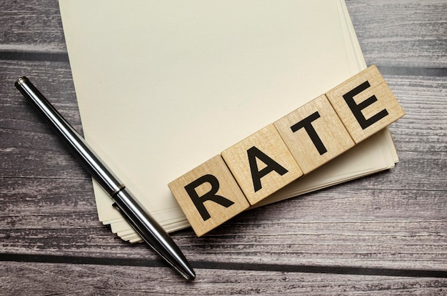 Rate Word Written In Wooden Cubes on notebook with pen