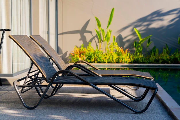 Rattan bench standing next to swiming pool with small garden freshness environment backgroundrelax casual home interior design concept