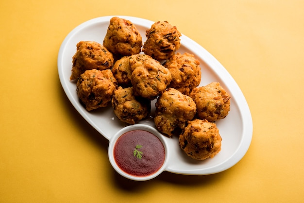 Rava Bhajj or bhajiya also known as suji Pakoda or semolina Pakora, served with tomato ketchup. selective focus