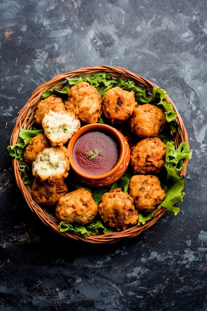 Photo rava bhajj or bhajiya also known as suji pakoda or semolina pakora, served with tomato ketchup. selective focus