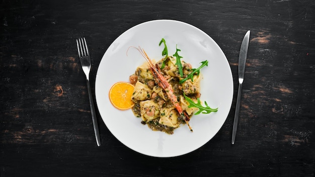 Ravioli with shrimp and seafood Italian cuisine Dumplings In a plate on a wooden background Top view Free copy space