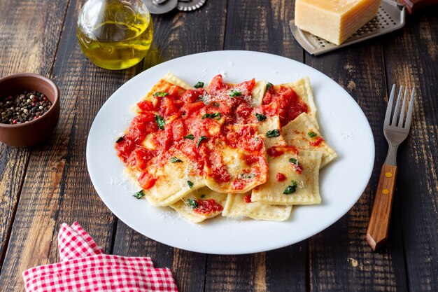 Ravioli with tomato sauce, spinach and parmesan cheese. Healthy eating. Vegetarian food. Italian cuisine.