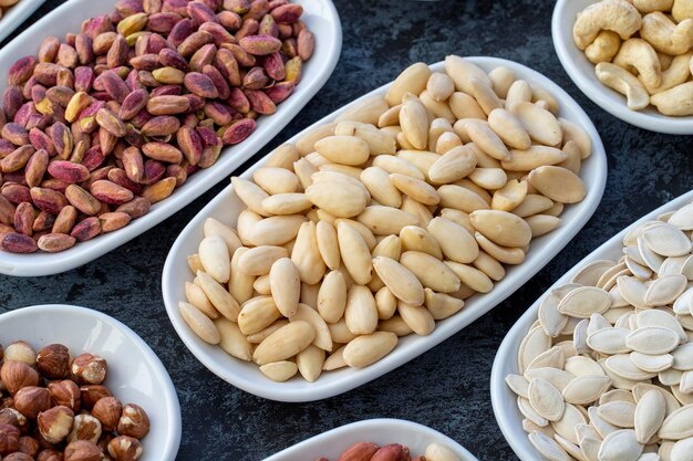 Raw almonds in selective focus Types of nuts found in bulk on a dark background Top view nuts