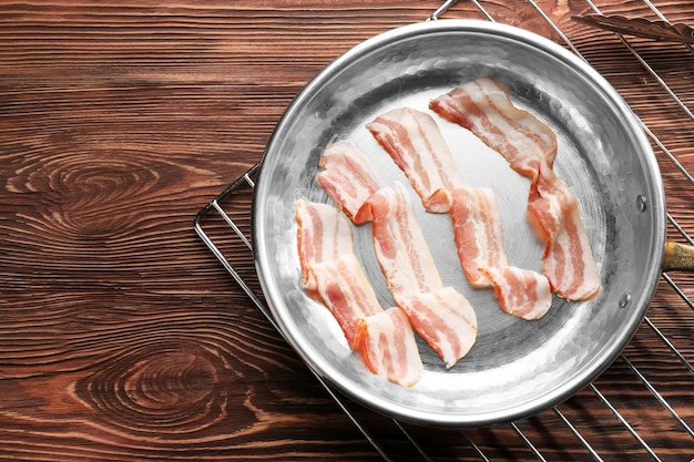 Raw bacon slices on pan