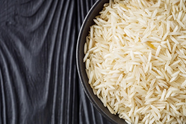 raw basmati rice on a black wooden background