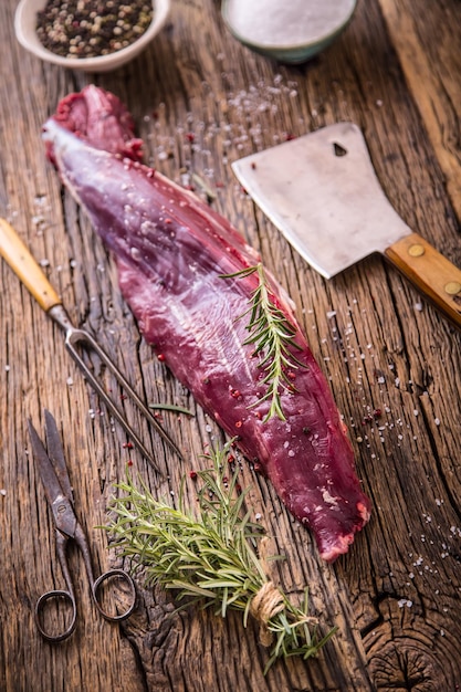 Photo raw beef meat raw beef tenderloin steak on a cutting board with rosemary pepper salt in other positions