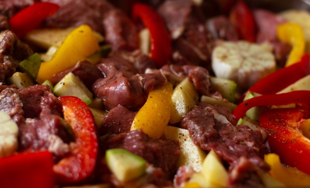 Raw beef meat with raw vegetables: zucchini, garlic, red and yellow pepper with natural spices and herb