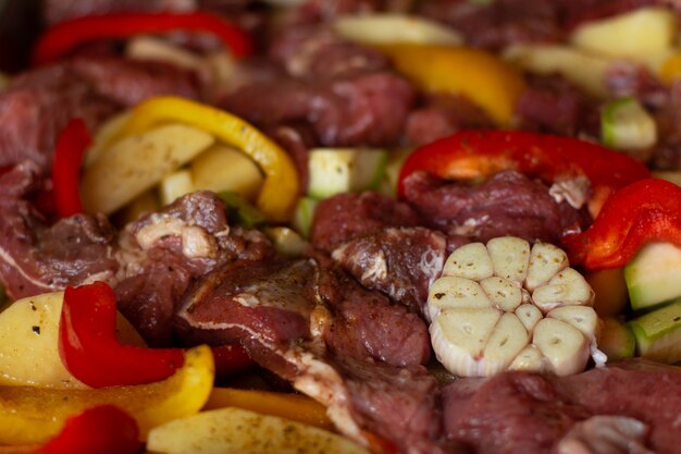 Raw beef meat with raw vegetables: zucchini, garlic, red and yellow pepper with natural spices and herb