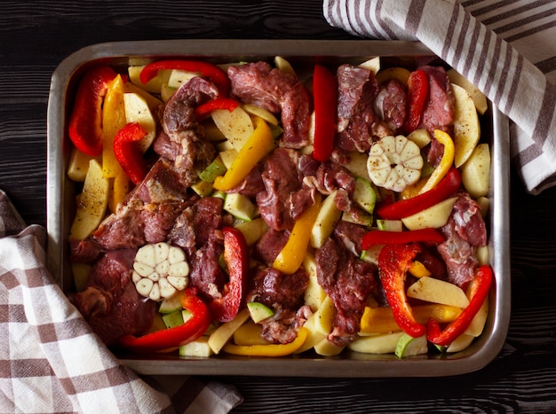 Raw beef meat with raw vegetables: zucchini, garlic, red and yellow pepper with natural spices and herb