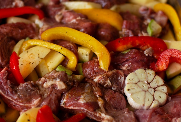 Raw beef meat with raw vegetables: zucchini, garlic, red and yellow pepper with natural spices and herb