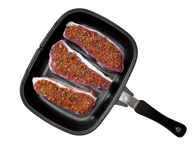 Raw beef steaks in a pan