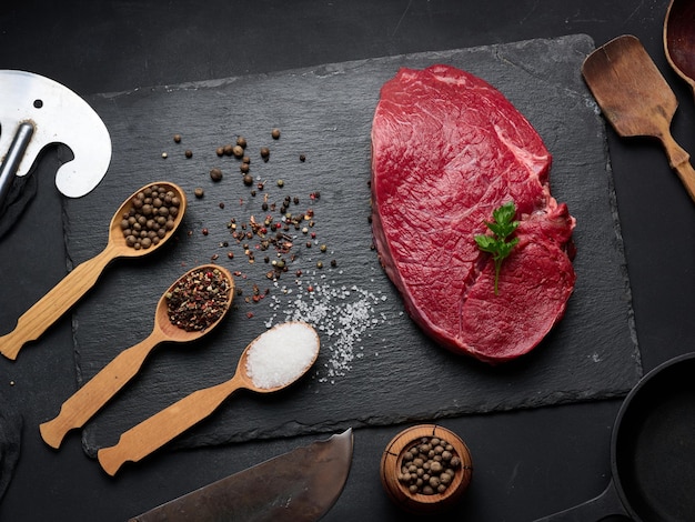 Raw beef tenderloin lies on a board black table