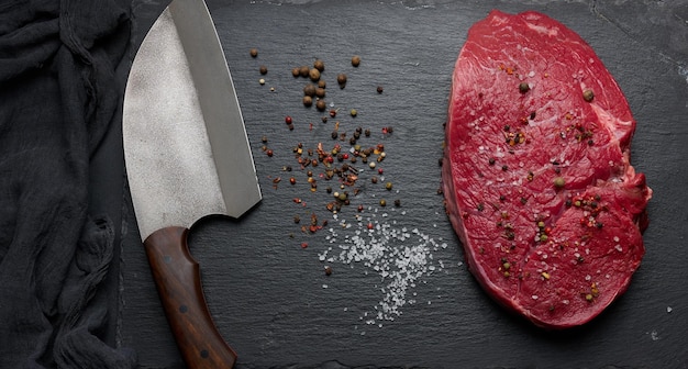 Raw beef tenderloin lies on a board black table