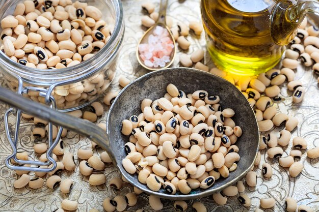 Raw black eyed peas and a metallic ladle