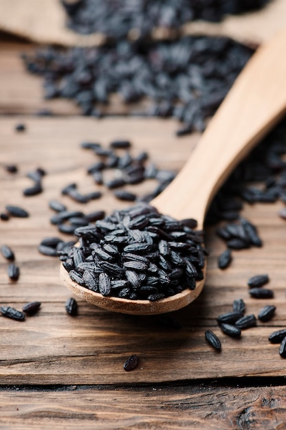 Raw black rice on the wooden table