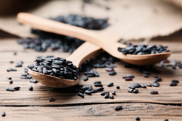 Raw black rice on the wooden table