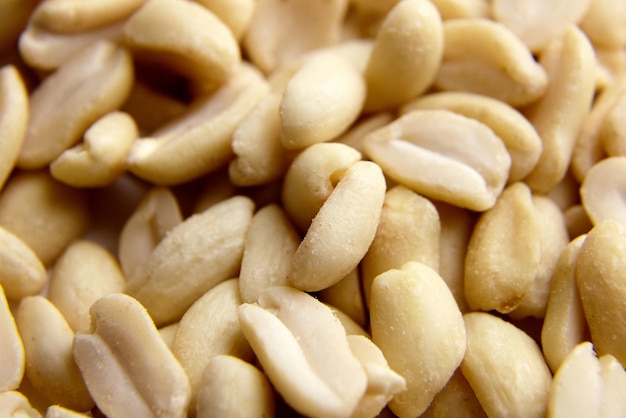 Raw blanched peanuts as food background closeup