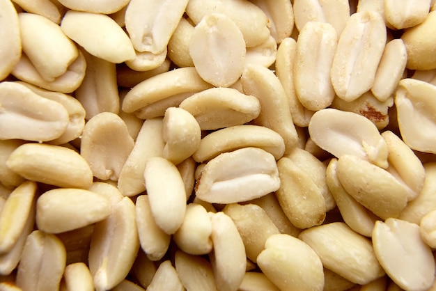 Raw blanched peanuts as food background closeup