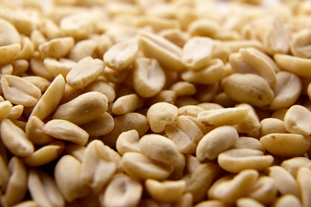 Raw blanched peanuts as food background closeup