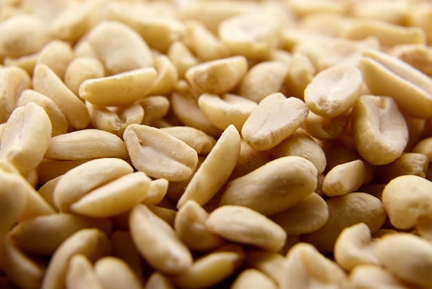 Raw blanched peanuts as food background closeup