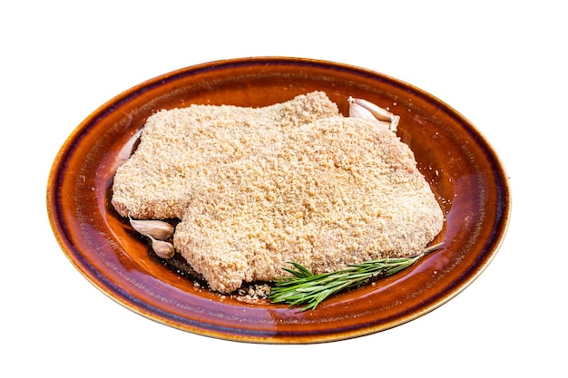 Raw Breaded German Wiener schnitzel on a rustic plate with herbs Isolated on white background