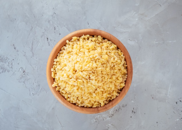 Raw bulgur grain in a bowl. Healthy, dietary, vegan, gluten free product. Healthy eating concept. Organic product made from wheat grains. Source of natural protein, fiber and fat. Top view. Soft focus