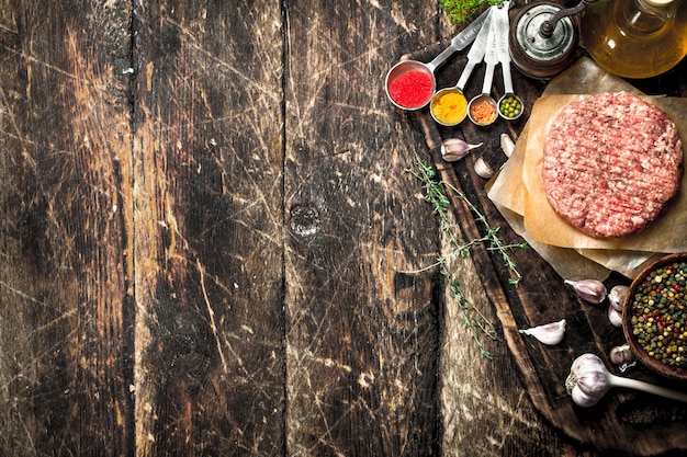 Raw burger from beef with spices and olive oil.