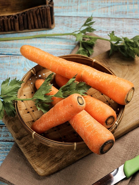 Raw Carrots on blue rustic table. Selective focus. Rough texture from carrots skin