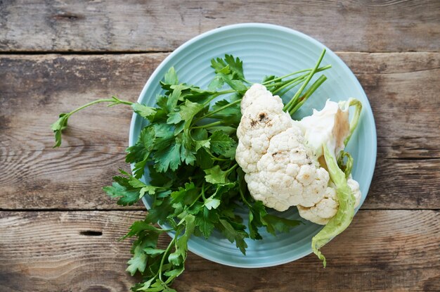 Raw cauliflower and fresh parsley on plate