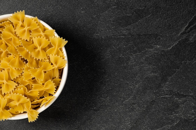 Raw Cavatappi Cellentani pasta in a plate isolated on dark background top view