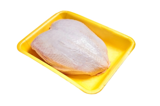 Raw chicken breast with skin in a yellow plastic container. Poultry meat in tray. Nobody. Isolated on white background