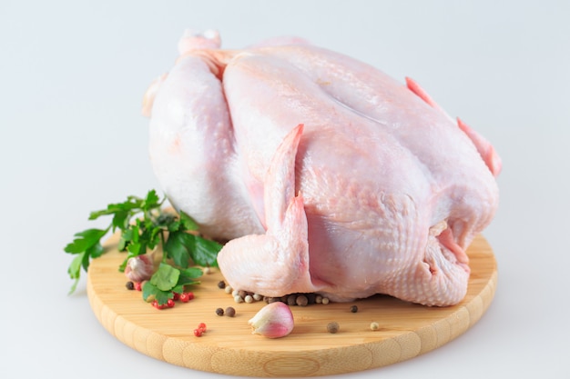 Raw chicken carcass on the cutting board isolated on white