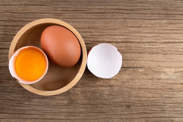 Raw chicken eggs on rustic wooden background