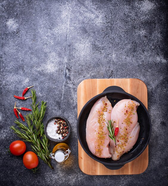 Raw chicken fillet in cast iron pan