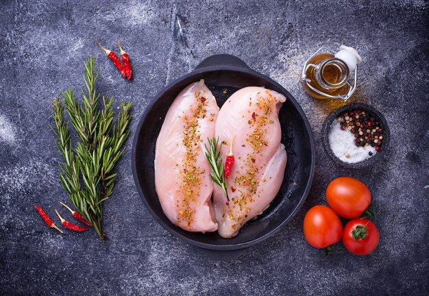 Raw chicken fillet in cast iron pan