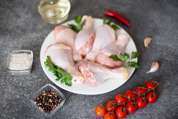 raw chicken legs with spices on a stone background