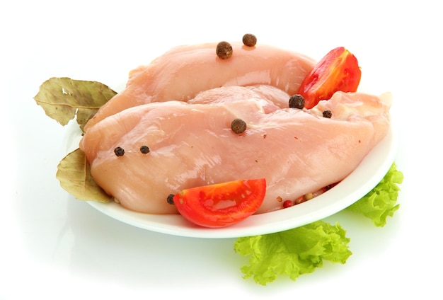 Raw chicken meat with spices on plate isolated on white