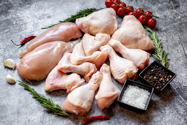 Raw chicken on a table with spices and herbs