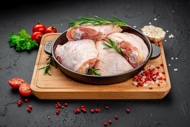 Raw chicken thigh on black background