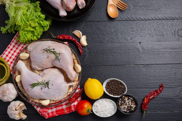 Raw chicken thighs on the dark wooden surface.